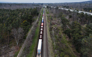 high angle view of a cargo train driving through the forest in bad weather