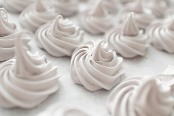 many spiral beige meringues background