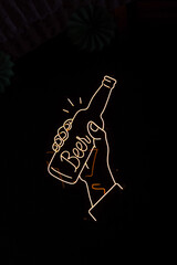 Photo yellow neon sign in a brewery in Cartagena, it is a hand holding a beer and forming the word...