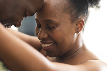 Naklejka premium Happy senior african american couple touching their foreheads and embracing