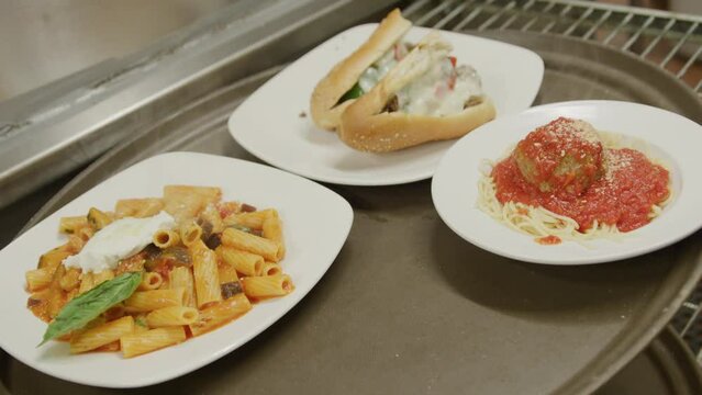 Three italian dishes in commercial restaurant kitchen