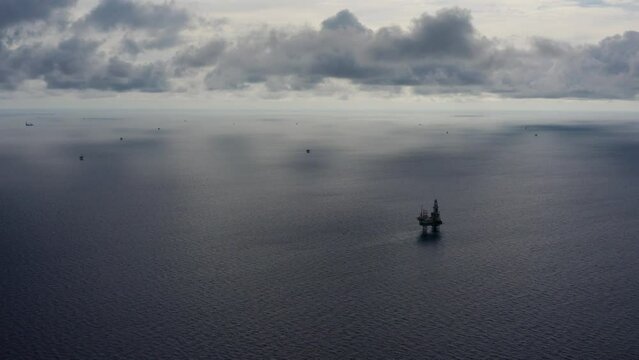 Jack up drilling rig and production platform in the middle of the ocean during couldy time
