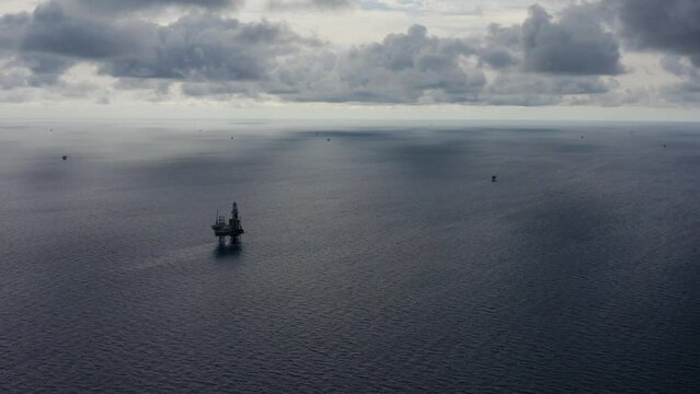 Jack up drilling rig and production platform in the middle of the ocean during couldy time
