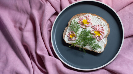 creative sandwich with soft cheese and pink pasta tarama greens, flowers