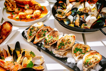 diferentes tipos de mariscos sobre platos negros en fondo blanco