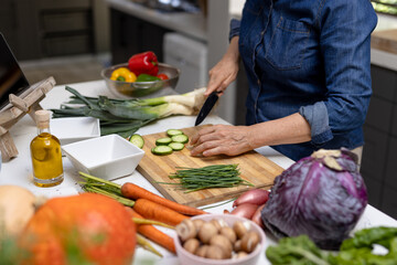 Midsection of senior caucasian woman chopping vegetables in kitchen