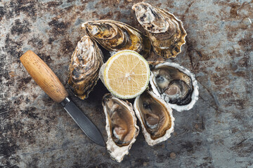 ostras frescas al natural con limón en fondo de piedra café