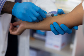 African american male doctor and biracial female patient collectiong blood at doctor's office