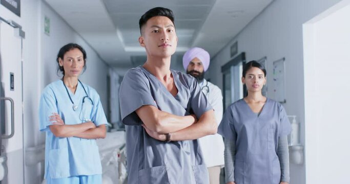Portrait of diverse doctors and nurses in corridor at hospital, in slow motion
