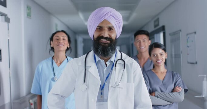 Portrait of diverse doctors and nurses smiling in corridor at hospital, in slow motion