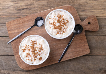Canjica or munguza, typical brazilian white corn sweet cream with cinnamon over wooden table