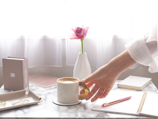 明るい窓辺でリラックスタイム、ノートとコーヒーを並べたモーニングのイメージ