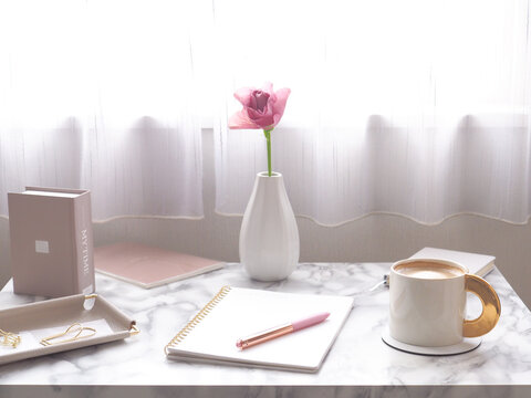 明るい窓辺でリラックスタイム、ノートとコーヒーを並べたモーニングのイメージ