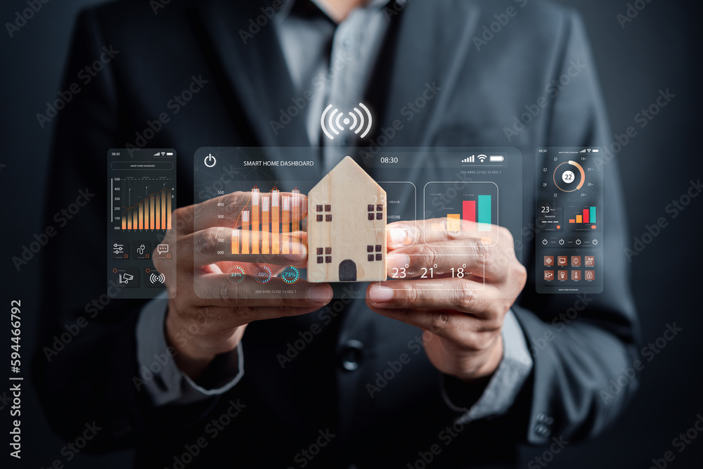 Poster Smart home digital remote control on smartphone concept. internet of things in technology control. Businessman holding wooden house with virtual smart home icon function.
