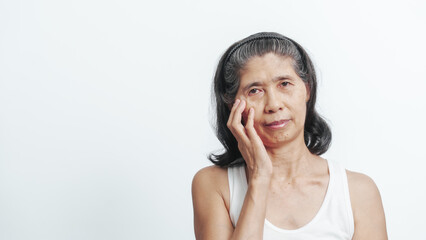 Close up face of female elderly mature older asian chinese housewife applies anti aging facial cream on face, old skincare treatment