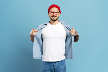 Portrait of smiling confident asian man, hipster wearing red hat, stylish eyeglasses, white t shirt...