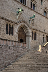 Fototapeta na wymiar Italy, Umbria, Perugia. Stairs leading to the entrance of the Priory Palace (Palazzo dei Priori). A Griffin and a Lion, symbols of the city.