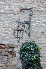 Italy, Umbria. Wrought iron lantern on a stone wall in the historic town of Montone.