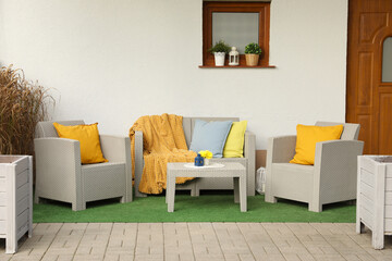 Beautiful rattan garden furniture and different decor elements outdoors