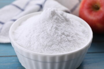 Sweet fructose powder and apple on light blue wooden table, closeup