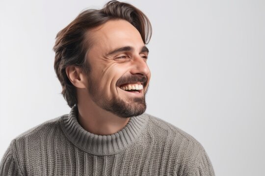Portrait of a handsome young man laughing and looking away isolated over white background