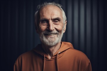 Portrait of a smiling senior man in an orange hoodie.