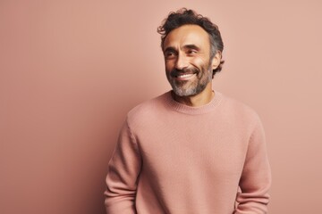 Obraz premium Portrait of a smiling man in a pink sweater on a pink background