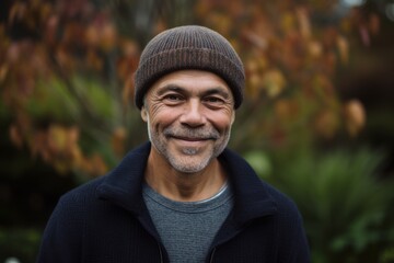 Naklejka na ściany i meble Portrait of a senior man smiling in the park on an autumn day
