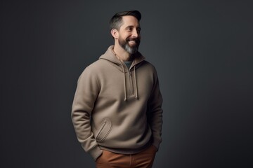 Fototapeta premium smiling bearded man in hoodie looking at camera isolated on grey