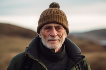 Portrait of a senior man wearing a hat in the countryside.