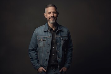 Fototapeta premium Handsome middle-aged man in jeans jacket on dark background