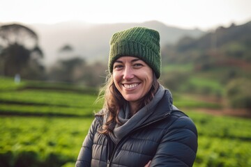 Portrait of smiling woman standing at tea plantation in the morning.
