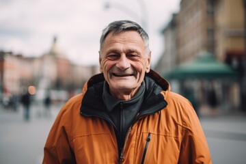 Portrait of a smiling senior man in an orange jacket on the street