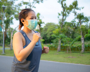 Portrait of a beautiful Asian woman in sportswear, standing with her back, stretching before exercising outdoor in the park in the morning to achieve a healthy lifestyle. healthy  warming up