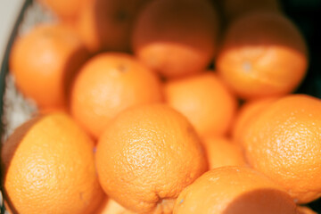 Many oranges sitting in a tray at the market place. Tropical fruits from citrus family being on sale
