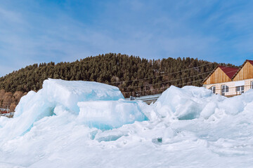 Lake Baikal in early spring. The village of Listvyanka is a popular travel destination. Ice mountains on the frozen Baikal