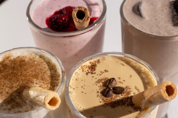 Glasses with delicious milkshakes with nuts, caramel, strawberry and whipped cream