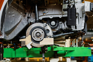 Finished automobile suspension with brake and rotor in shop