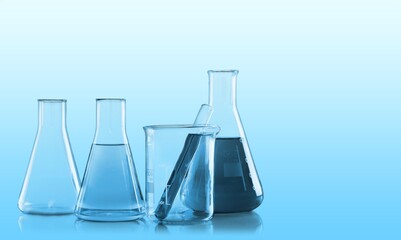 Glass empty lab test tubes on a light blue  background.