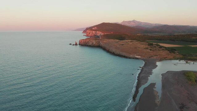 Sunset at Evia Greece coastline. Blue ocean and orange cliffs