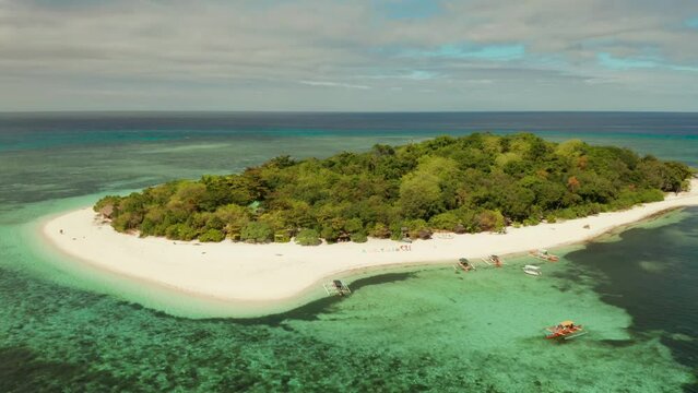 Tropical island Mantigue and sandy beach surrounded by atoll coral reef and blue sea, aerial view. Small island with sandy beach. Summer and travel vacation concept, Camiguin Philippines Mindanao