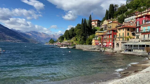 Panning shot revealing picturesque waterfront Italian village of Varenna in Como lake