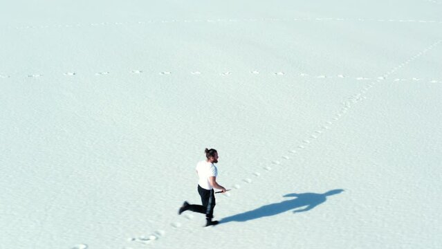 Aerial View Of Man Running In The Snow.
