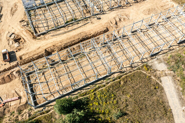 construction of new warehouse building or factory in suburb area. metal frame construction. drone photo.