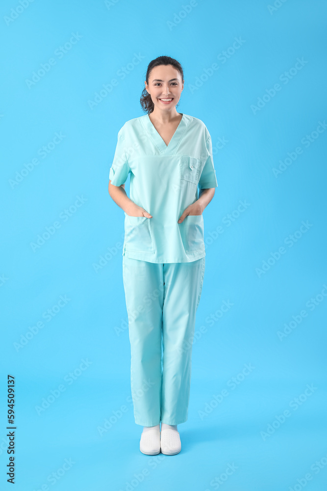 Wall mural Female medical assistant on light blue background