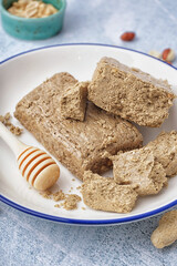 Plate of tasty halva on light background, closeup
