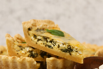 Pieces of delicious quiche on grey background, closeup