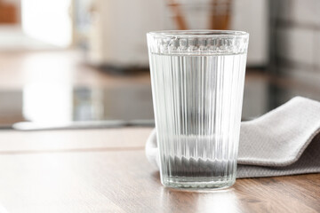 Glass of water and napkin on kitchen counter, closeup