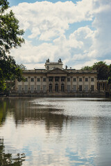Fototapeta na wymiar Baths classicist Palace on the Isle in Lazienki Park touristic place in Warsaw. Lazienki Royal Baths Park, Warsaw Poland. Mirror Reflection on the Lake. Nature in summer Baroque columns 
