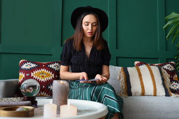 Young witch with tarot cards at home
